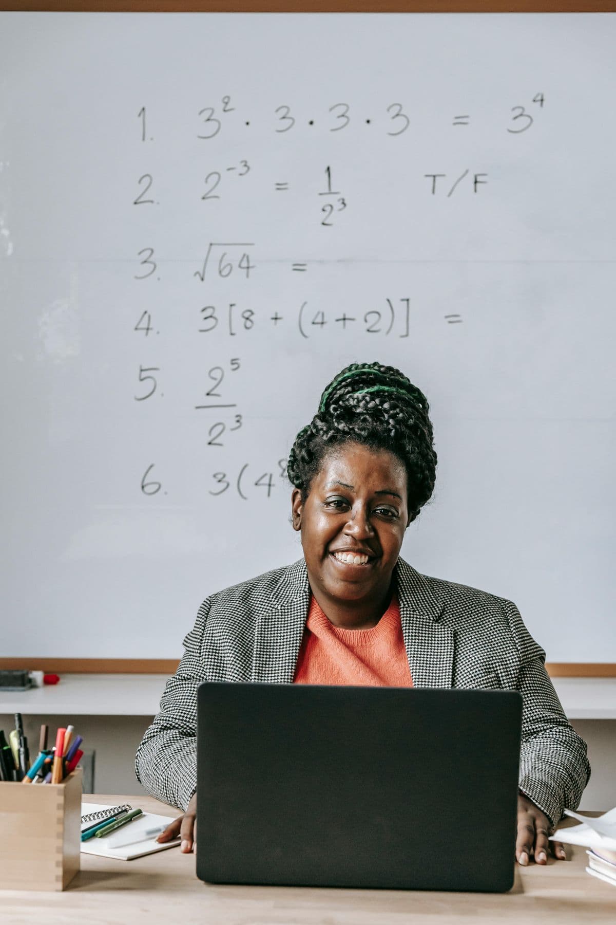 A trainer working on a laptop in a classroom